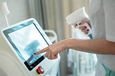 Bir kadın güzellik uzmanı diyot lazer epilasyon prosedürü yapıyor..