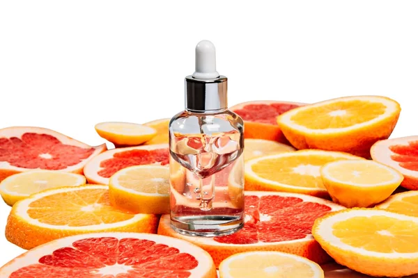 Een fles gezichtsserum op citrusschijfjes. — Stockfoto