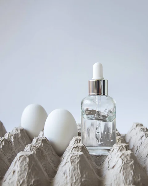 Glass bottle of egg serum for face. — Stock Photo, Image