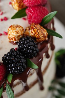 Lezzetli ve güzel el yapımı pasta. Tatil için şekerleme. Taze böğürtlen, yeşil yaprak ve şekerle süslenmiş tatlı..