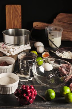 Kirazlı çikolatalı pasta yapmak için gerekli malzemeler. Tatlılar ahşap mutfak masasında. Pastırma. Lezzetli ve güzel bir Fransız tatlısı..