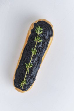 Fıstık kremalı ve siyah kremalı ekler. Keklerle süslenmiş kekler var. Beyaz mutfak masasında tatlı..