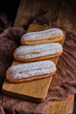 Klasik krema dolu ekler. pudra şekerle süslenmiş. Lezzetli ve güzel Fransız tatlısı..