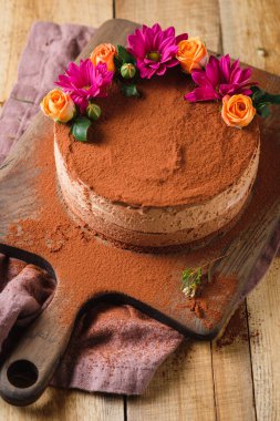 Şenlikli bir akşam yemeği için çikolatalı kek. Tatlı çiçekleri ve c