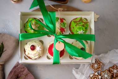 Yeni yıl hediyeleri seti. Noel hediyesi olarak bir kutu kek. Krem peynirli kekler ve fıstık-karamel dolgulu.