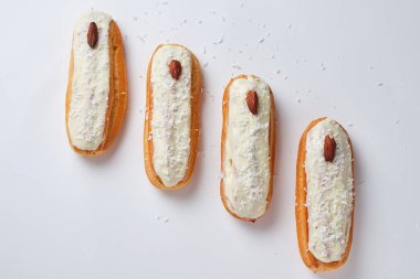 Hindistan cevizi taneli ekler ve beyaz çikolata jöleli bademler. Beyaz tabakta tatlı.