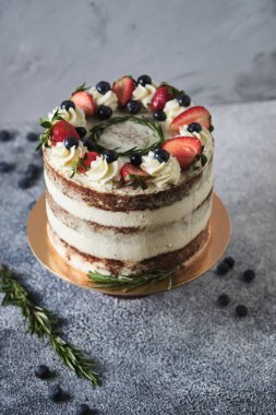 Tezgahta tereyağlı kremalı taze tatil pastası. Tatlı taze böğürtlen, otlar ve kremayla süslenmiş. Doğum günü tatlıları.