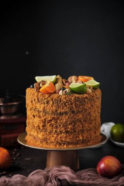 Cevizli ve kuru erikli ballı kek. Tatlı fındık, taze meyve, otlar ve kırıntılarla süslenmiş. Tatil için ev yapımı tatlılar..