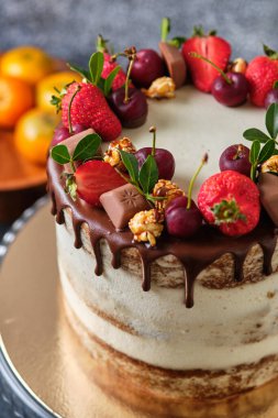 Lezzetli ve güzel el yapımı pasta. Tatil için şekerleme. Tatlı taze böğürtlenler, yeşil yapraklar, çiçekler ve şekerlerle süslenir..