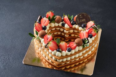 Taze çilek, ot ve krem peynir kremiyle süslenmiş ballı pasta. Sevdiğin için tatlı. Kalp keki.