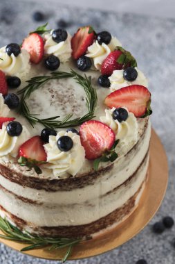 Tezgahta tereyağlı kremalı taze tatil pastası. Tatlı taze böğürtlen, otlar ve kremayla süslenmiş. Doğum günü tatlıları.