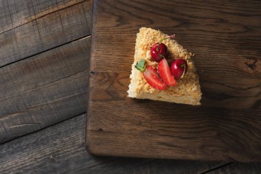 Kesik katmanlı pasta. Kremalı pasta, ekmek kırıntıları ve taze böğürtlenlerle süslenmiş..