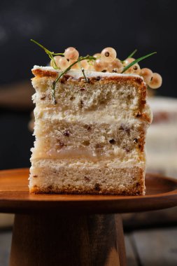 Krem peynirli ve üzümlü bir dilim ev yapımı kek. Taze böğürtlenlerle süslenmiş güzel bir tatlı..