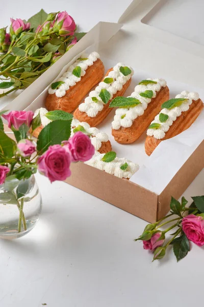 Λουλούδια Και Εκλέρ Διακοσμημένα Κρέμα Και Μέντα Λευκό Τραπέζι Επιδόρπιο — Φωτογραφία Αρχείου