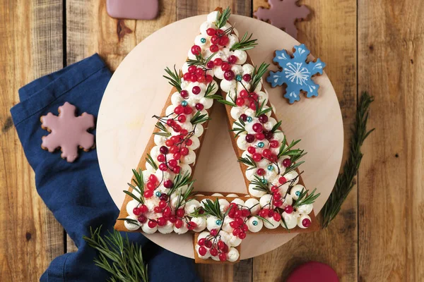 以圣诞树为形式做的新年蛋糕 一个漂亮的圣诞蛋糕 上面装饰着新鲜的浆果和香草 — 图库照片