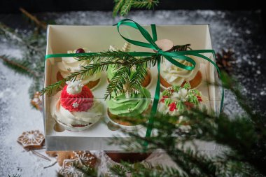 Yeni yıl hediyeleri seti. Noel hediyesi olarak bir kutu kek. Krem peynirli kekler ve fıstık-karamel dolgulu.