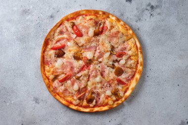 Pizza with tomatoes, bacon, pickled onions, honey mushrooms, mozzarella cheese, spices and tomato sauce. Flat lay. On a light background