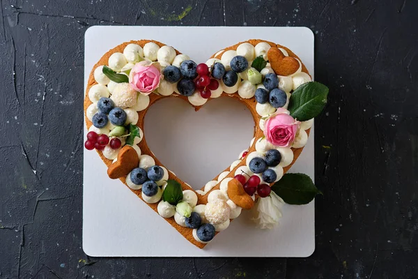 Honey cake with fresh blueberries, herbs and cream cheese cream. Dessert for a loved one. Heart cake.