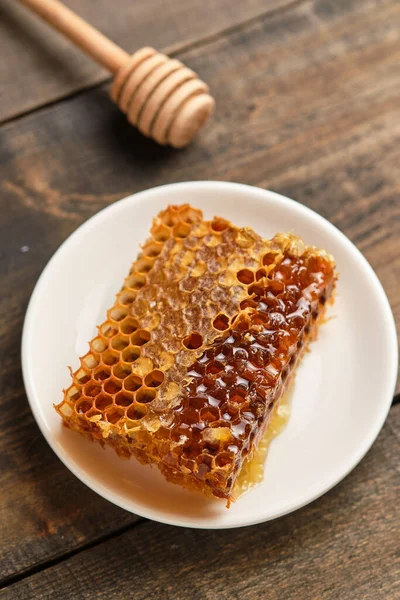 Honeycomb close-up. Fresh honey from the field and honey stick on an old wooden table.