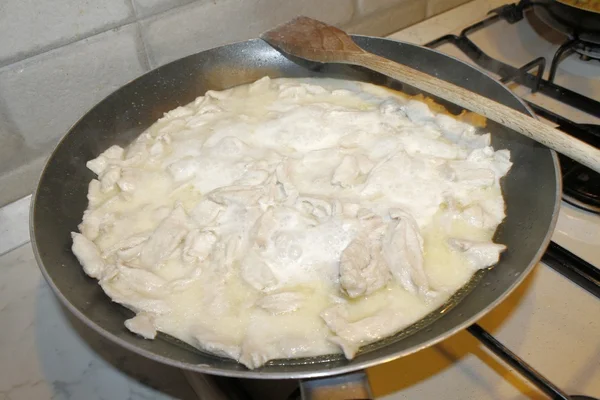 Piatto con piccoli pezzi di pollo e latte e olio — Foto Stock