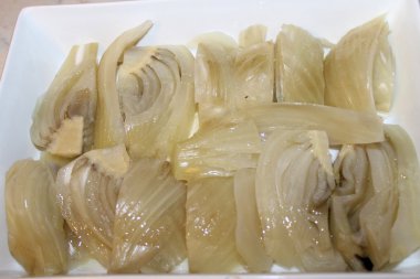 beyaz bir tepsi içinde pişmiş rezene ile çanak