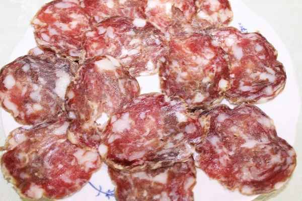 Sneetjes Italiaanse salami op witte plaat — Stockfoto