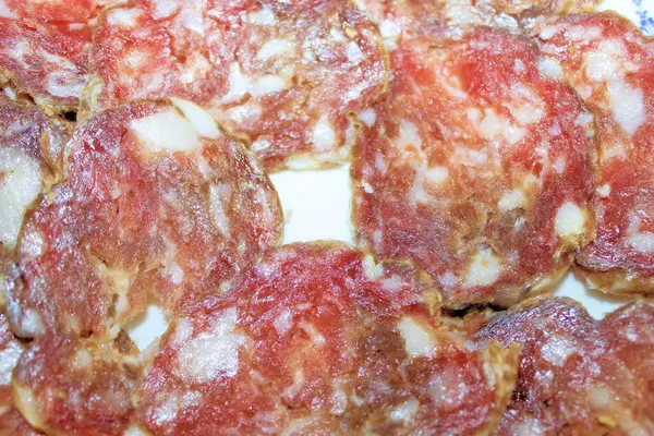 Rodajas de salami italiano en plato blanco — Foto de Stock