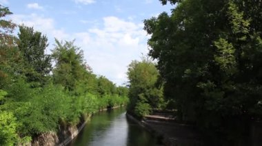 Çok eski bir taş köprü kemerin hemen altında ve köprünün altında nehirden akan bir su var.