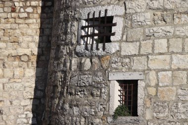 Kuzey İtalya 'daki ortaçağ Brescia şatosunun merlonları ve asma köprü kapısı olan taş duvar.