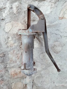 Duvarın arka planında paslı metal bir boru var.