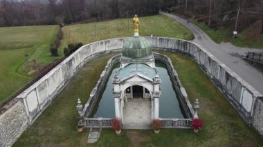 İtalya 'nın Rezzato kentindeki Madonna di Valverde Sığınağı' nın havadan görünüşü. Küçük bir gölü ve dağlarla çevrili altın heykeli olan tarihi dini bir anıt.