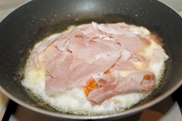 Страва зі смаженими яйцями і шинкою в кулінарній каструлі — стокове фото