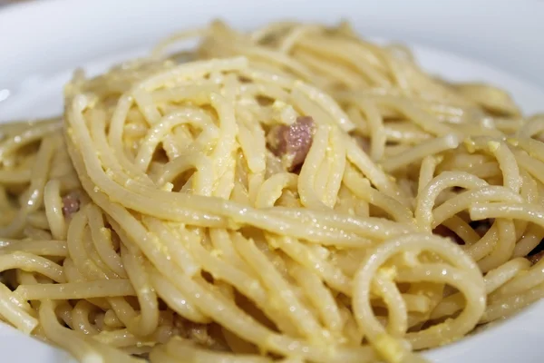 อาหารอิตาเลียนแบบดั้งเดิม พาสต้าสปาเก็ตตี้ที่เรียกว่า "คาร์บอนาร่า" กับเบคอนและไข่ — ภาพถ่ายสต็อก