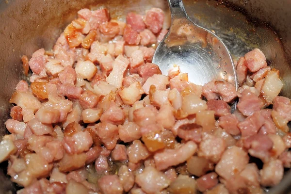 Dés de bacon frire avec de l'huile dans une casserole — Photo