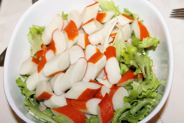 Салат с кусочками красного крабового палочки и свежим салатом — стоковое фото