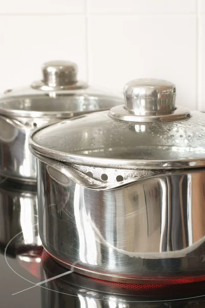 Saucepans on a halogen hob — Stock Photo, Image