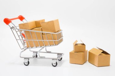 Çevrimiçi alışveriş konsepti için beyaz arka planda bir alışveriş arabasında bir sürü paket.