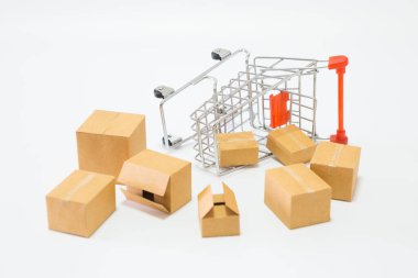 Çevrimiçi alışveriş konsepti için beyaz arka plana düşen bir sürü paket kutusu ve bir alışveriş arabası.