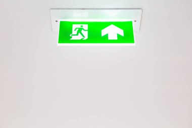 Beyaz tavan arkaplanındaki acil çıkış panosu ve kopyalama alanı