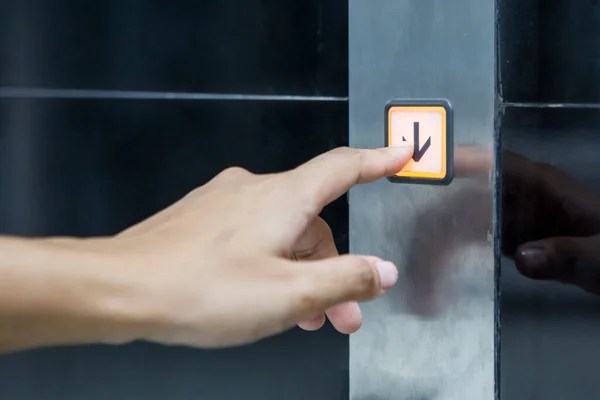 Kadınlar asansörü çağırmak için düğmelere basıyor.