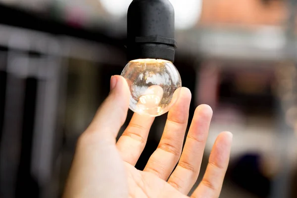 Foco Seletivo Mão Segurando Uma Lâmpada Fundo Embaçado Para Energia — Fotografia de Stock