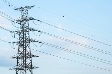 Mavi arkaplanda yüksek voltaj direğinin silueti