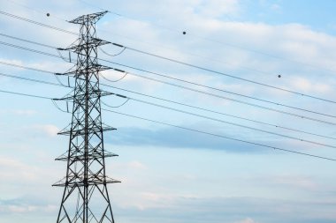 Mavi arkaplanda yüksek voltaj direğinin silueti