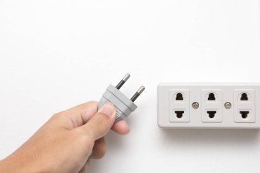 Hands holding plugged and power socket on white background