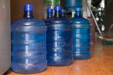 Empty plastic drinking water tanks on the floor