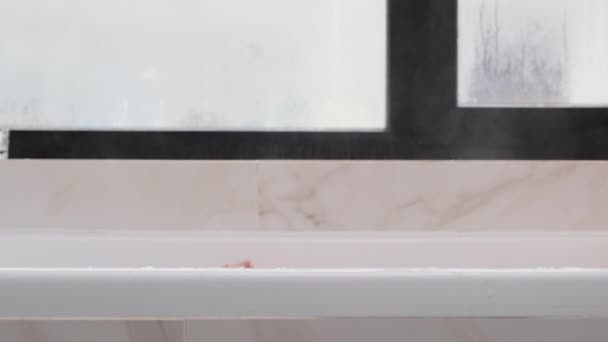 Side view of the bathroom. A beautiful blonde woman emerges from under the water. Relax concept. Steam comes from hot water — Stock Footage Side view of the bathroom. A beautiful blonde woman emerges from under the water. Relax concept. Steam comes from hot water Royalty Free Stock Footage