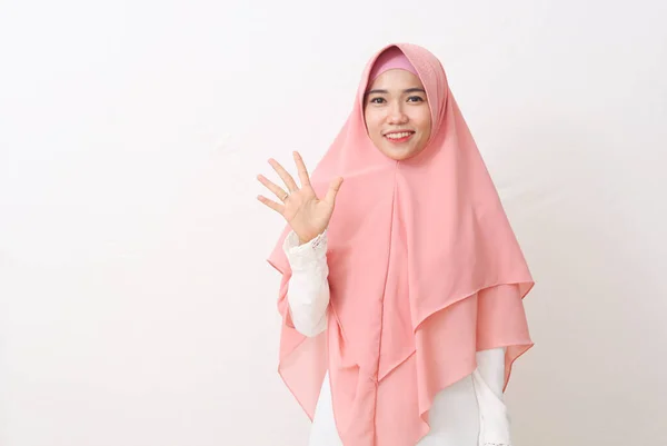 ベールまたはヒジャーブを身に着けている幸せなアジアのイスラム教徒の女性の肖像画は自信に満ちて笑顔で5番目の指を指しています コピースペースと白の背景に隔離された — ストック写真