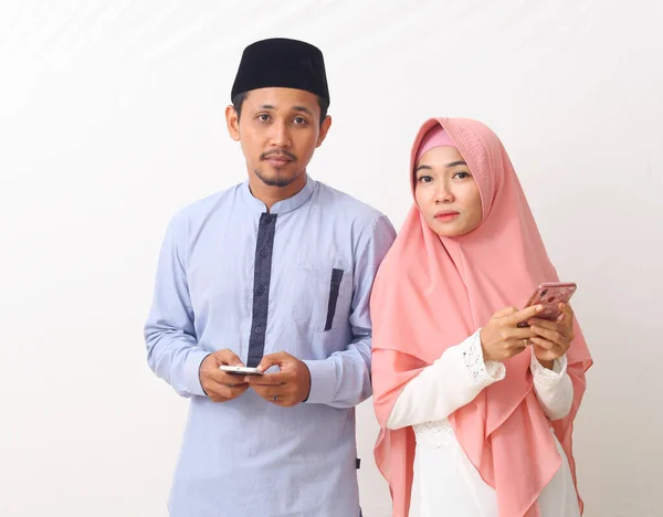 Potret Pasangan Muslim Asia Menggunakan Smartphone Saat Melihat Kamera Terisolasi — Stok Foto