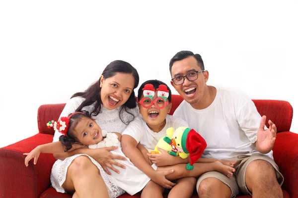 亚洲快乐的家庭庆祝圣诞节 照片上快乐的印尼家庭 白色的 圣诞装饰坐在沙发上 与白种人隔离 — 图库照片