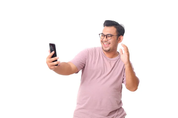 照片中快乐的亚裔男性手持智能手机 戴着眼镜 身穿紫色衬衫 他得到了一些好消息 与白种人隔离 — 图库照片